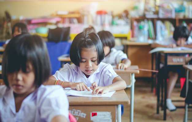 Students sitting at desks in a classroom, quietly writing in notebooks during a focused lesson.